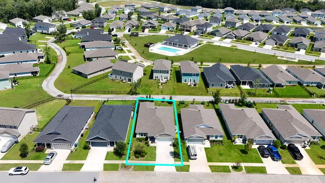 an aerial view of residential houses with outdoor space and parking