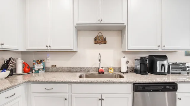 a kitchen with stainless steel appliances granite countertop a sink a stove and cabinets