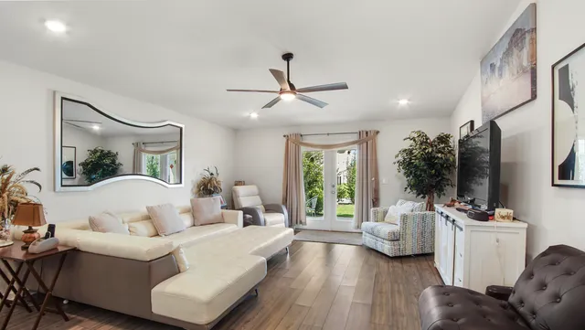 a living room with furniture floor to ceiling window and a flat screen tv