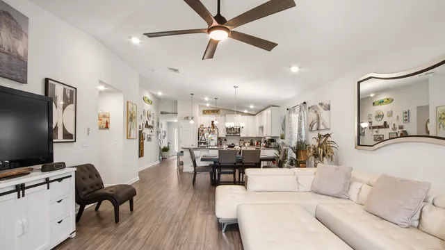 a kitchen with stainless steel appliances kitchen island granite countertop a dining table chairs and a refrigerator