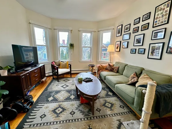 a living room with furniture a rug and a flat screen tv