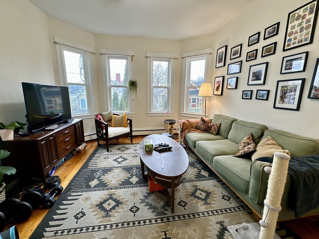 a living room with furniture a rug and a flat screen tv