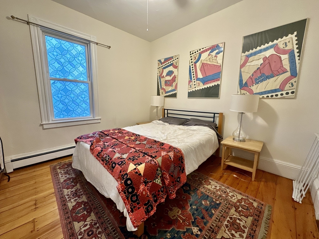 11 Sheridan Street, Unit 2 Boston, MA 02130 - Photo 15 of 17 a bedroom with a bed and a painting on the wall