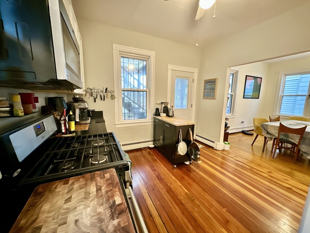 11 Sheridan Street, Unit 2 Boston, MA 02130 - Photo 4 of 17 a living room with furniture a dining table and chairs with wooden floor