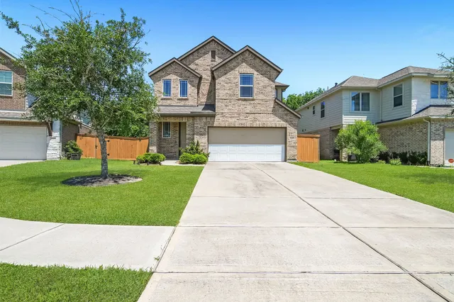 a front view of a house with a yard and trees