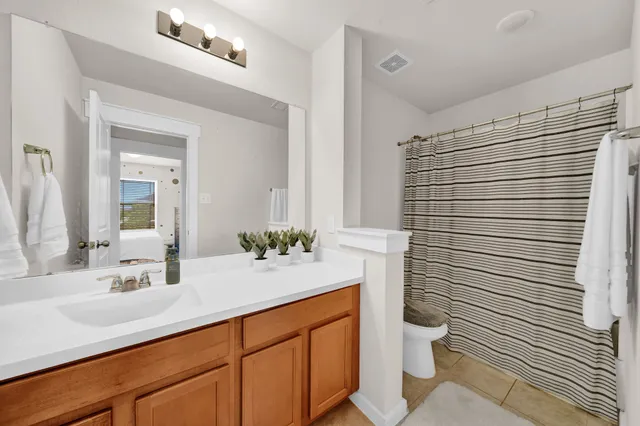 a bedroom with a bed and a flat tv screen on dresser