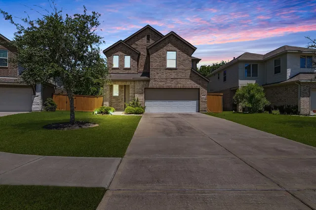 a front view of a house with a yard and trees