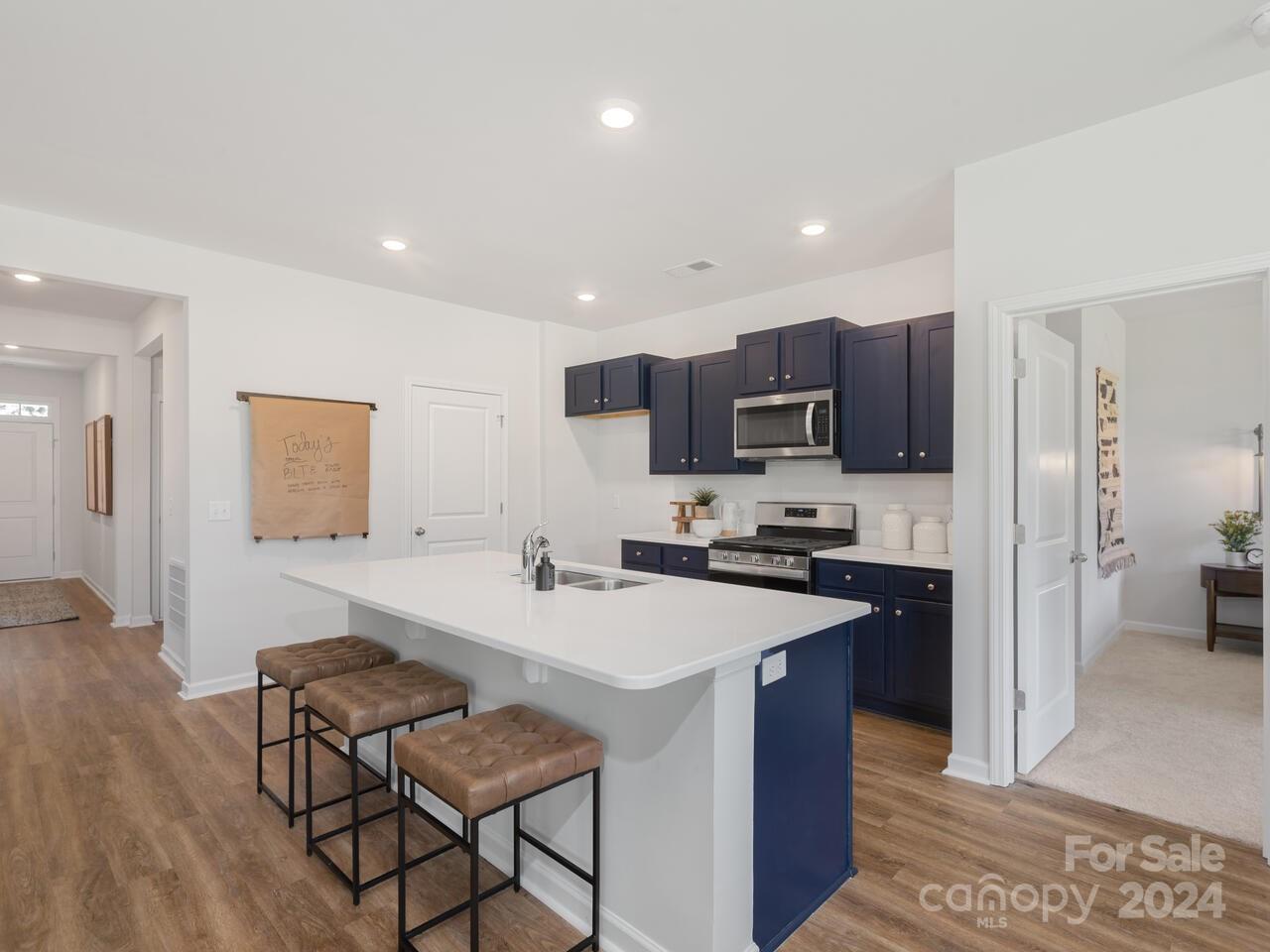 63 Dandelion Road Fletcher, NC 28732 - Photo 6 of 27 a kitchen with a sink a microwave a refrigerator and chairs