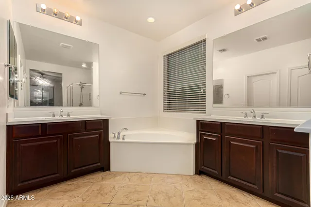 an empty room with chandelier fan and windows