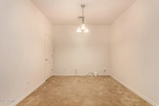 wooden floor in an empty room with a chandelier fan