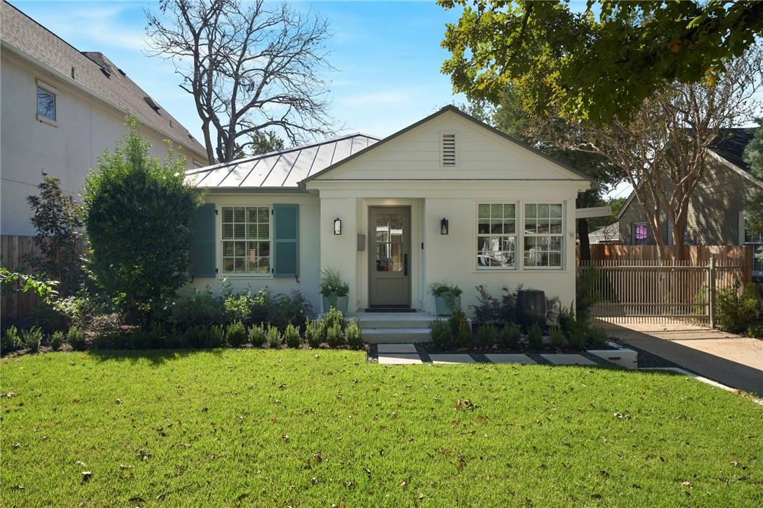 a view of a brick house with a yard and plants