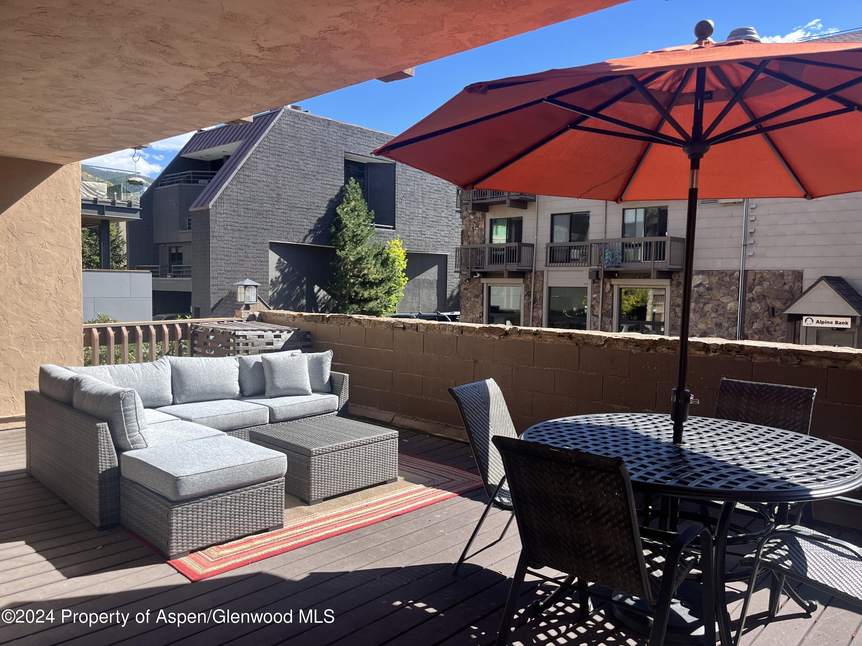 605 East Main Street, Unit 7 Aspen, CO 81611 - Photo 11 of 13 a view of a patio with couches table and chairs under an umbrella