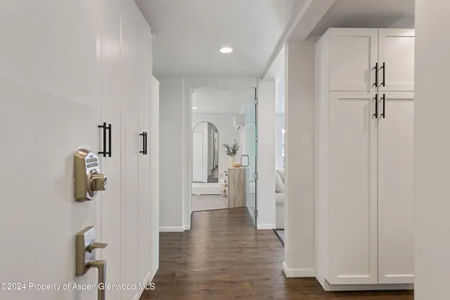 a view of a hallway with wooden floor and closet