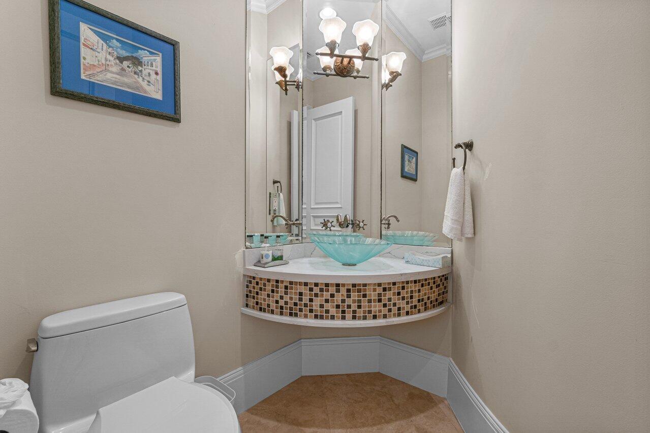 6103 North Ocean Boulevard Ocean Ridge, FL 33435 - Photo 11 of 53 a bathroom with a toilet a sink and a mirror