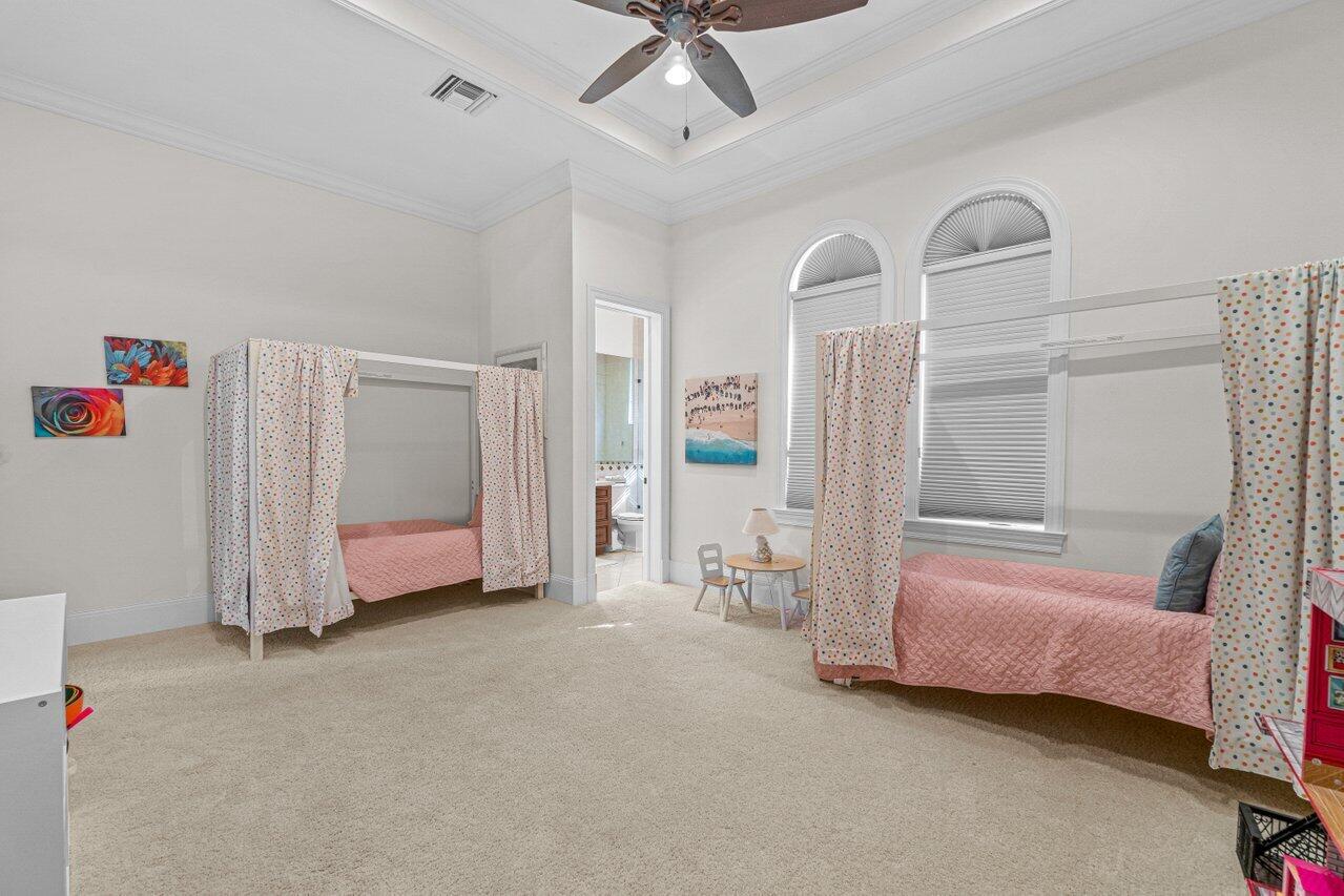 6103 North Ocean Boulevard Ocean Ridge, FL 33435 - Photo 15 of 53 a spacious bedroom with a bed and a chandelier