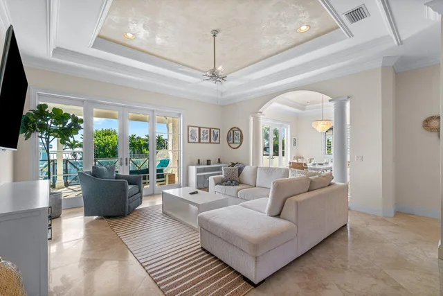 a living room with furniture a flat screen tv and a chandelier