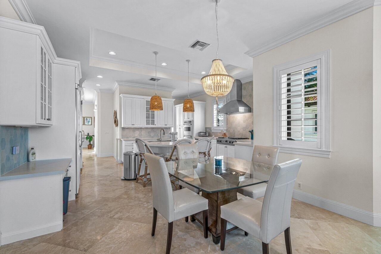 6103 North Ocean Boulevard Ocean Ridge, FL 33435 - Photo 24 of 53 a view of a dining room with furniture and a chandelier