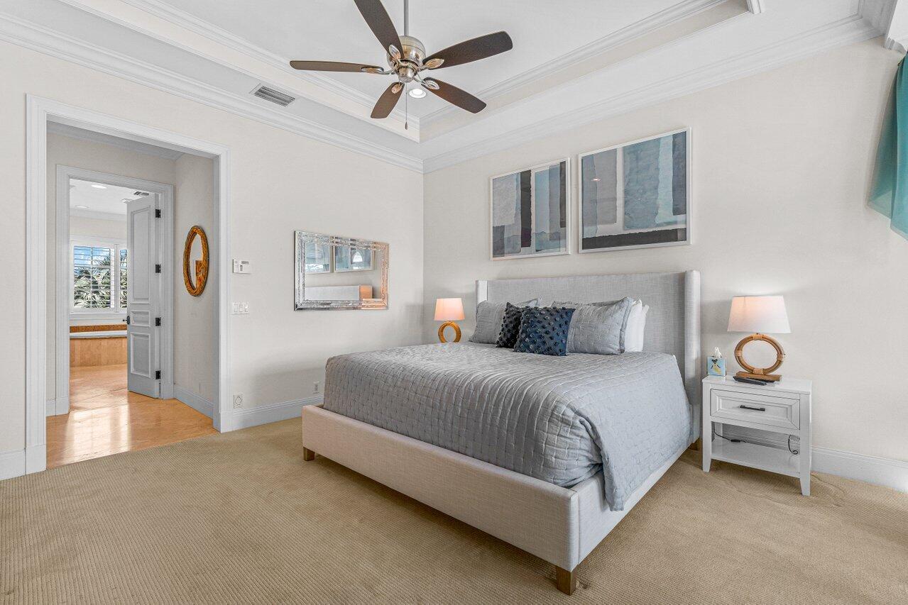 6103 North Ocean Boulevard Ocean Ridge, FL 33435 - Photo 29 of 53 a bedroom with a bed and ceiling fan