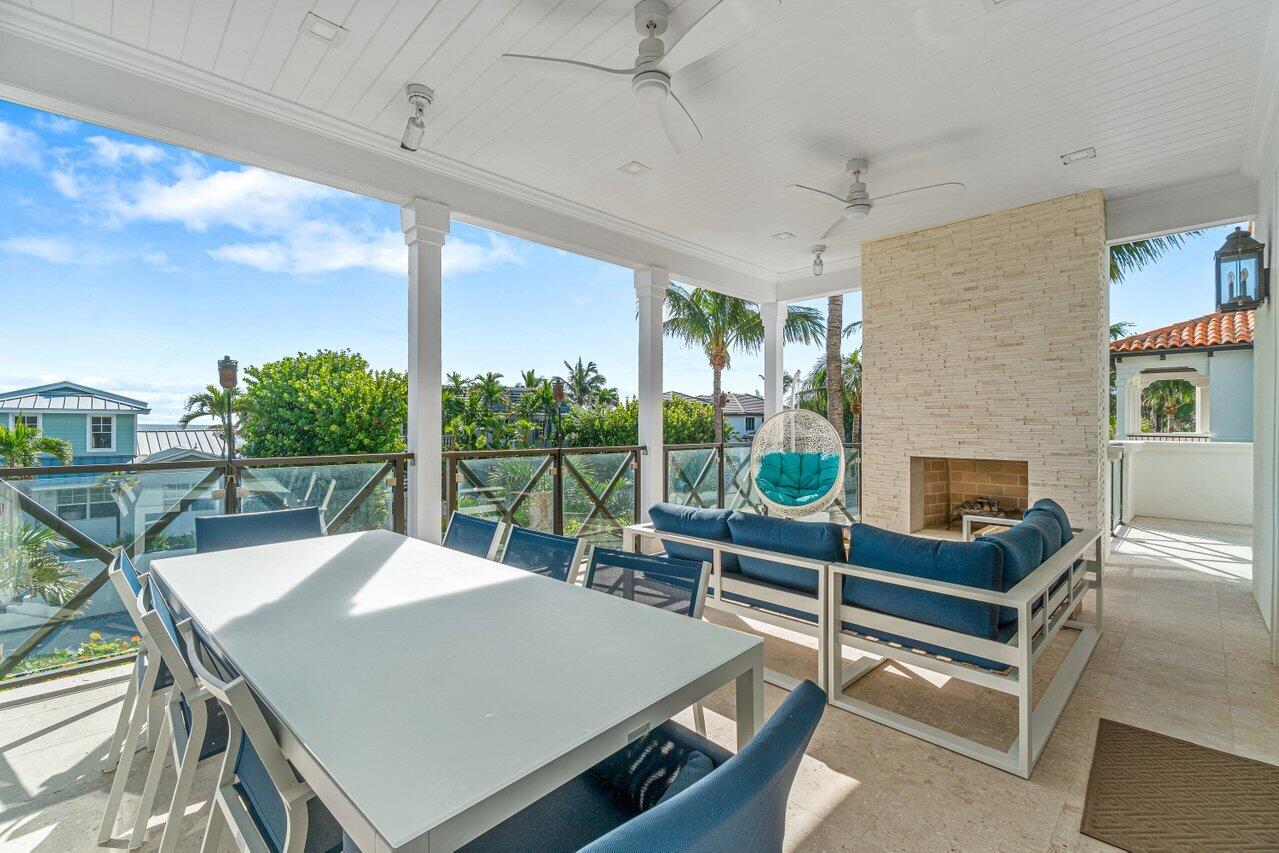 6103 North Ocean Boulevard Ocean Ridge, FL 33435 - Photo 34 of 53 a view of a patio with a table chairs and a fireplace