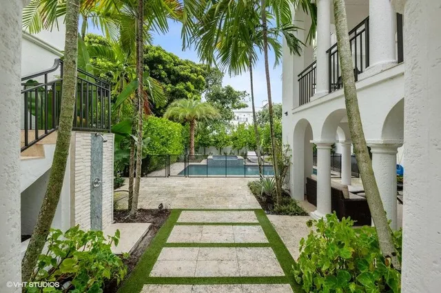 a view of a house with large windows and flower plants