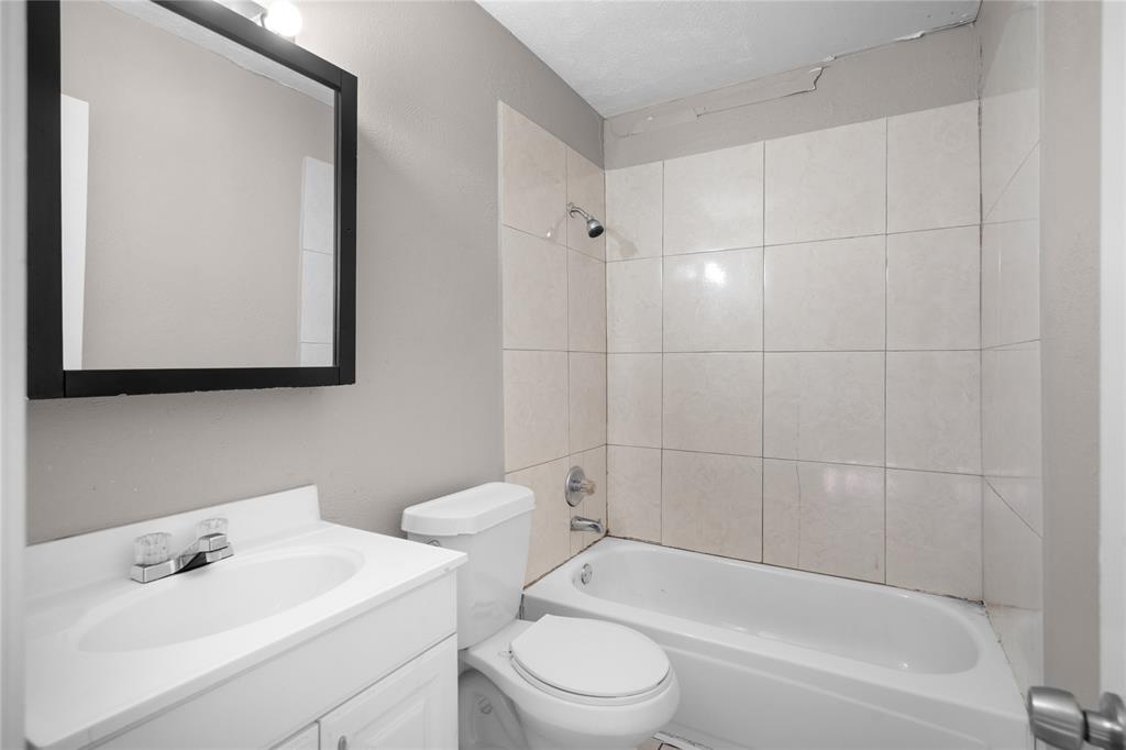 9319 Rutherglen Drive Dallas, TX 75227 - Photo 12 of 20 a bathroom with a toilet a sink and bathtub