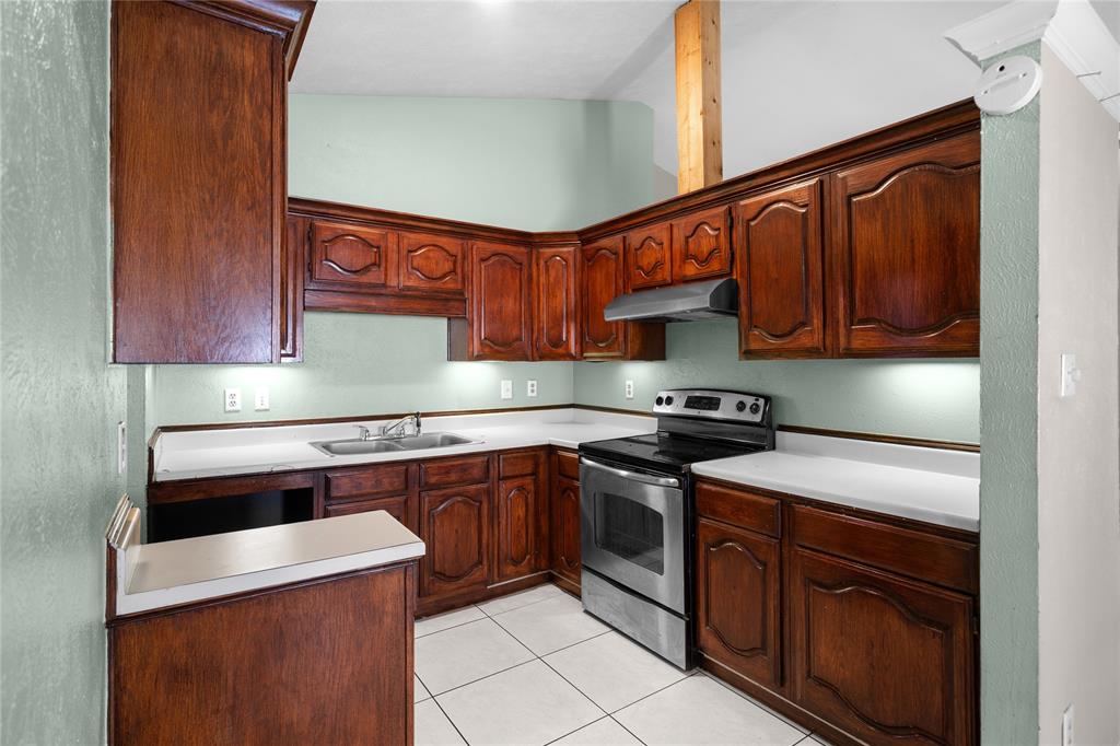 9319 Rutherglen Drive Dallas, TX 75227 - Photo 2 of 20 a kitchen with stainless steel appliances granite countertop a sink stove and cabinets