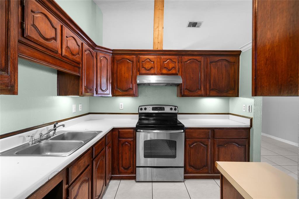 9319 Rutherglen Drive Dallas, TX 75227 - Photo 3 of 20 a kitchen with a sink stove and cabinets