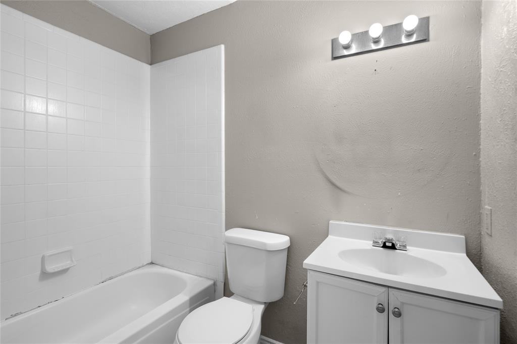 9319 Rutherglen Drive Dallas, TX 75227 - Photo 10 of 20 a bathroom with a sink a toilet and a bathtub