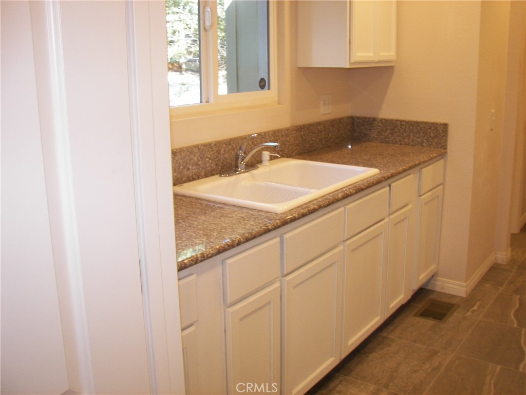 24977 Crest Forest Drive Crestline, CA 92325 - Photo 21 of 28 a bathroom with a granite countertop sink and a mirror