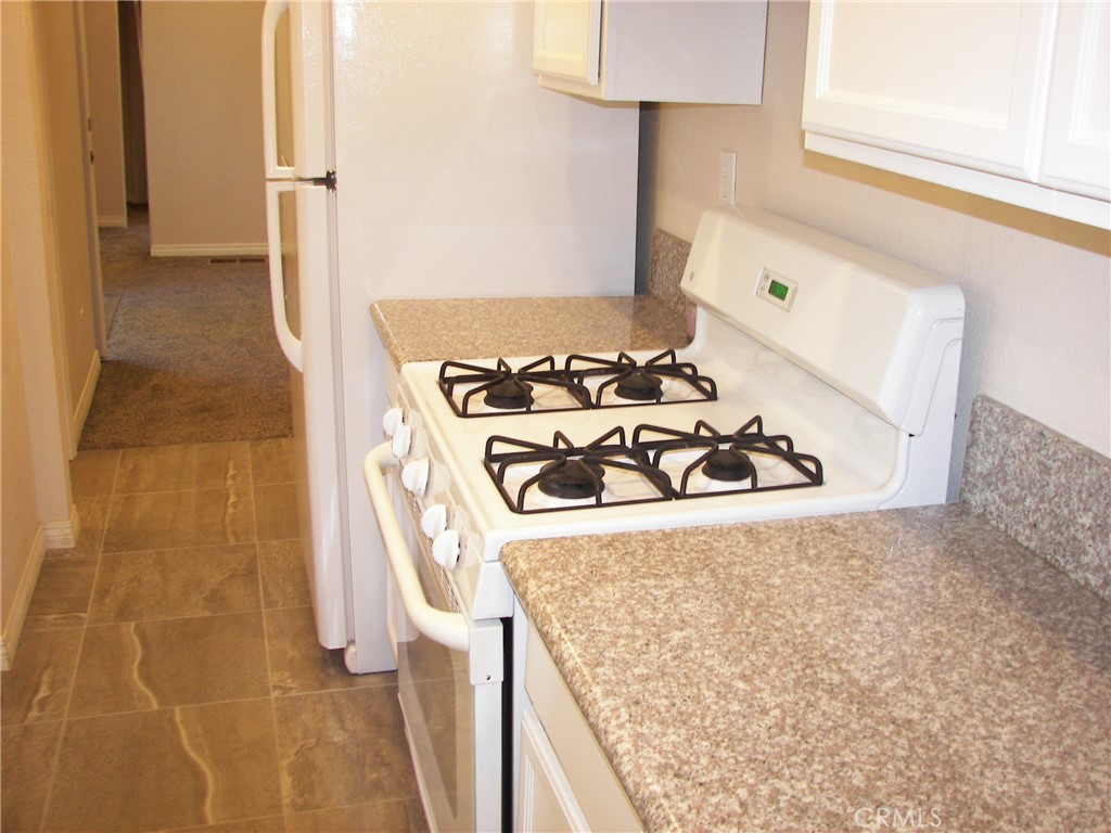 24977 Crest Forest Drive Crestline, CA 92325 - Photo 22 of 28 a kitchen with a stove and a refrigerator