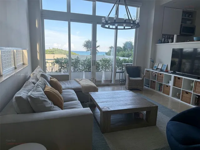 a living room with furniture and a chandelier
