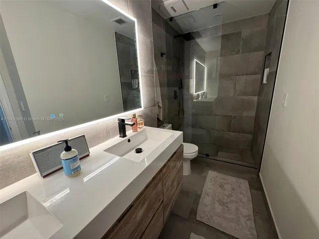 a bathroom with a sink a toilet and shower