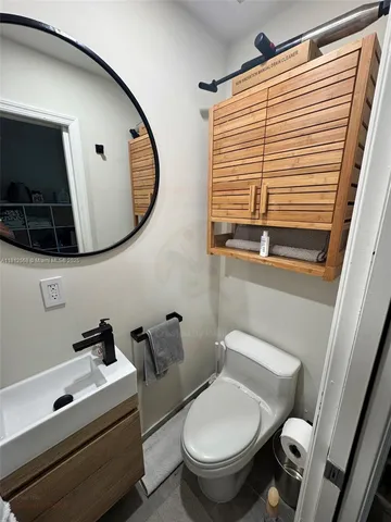 a bathroom with a toilet a sink and a mirror