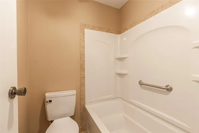 a white toilet sitting next to a bath tub