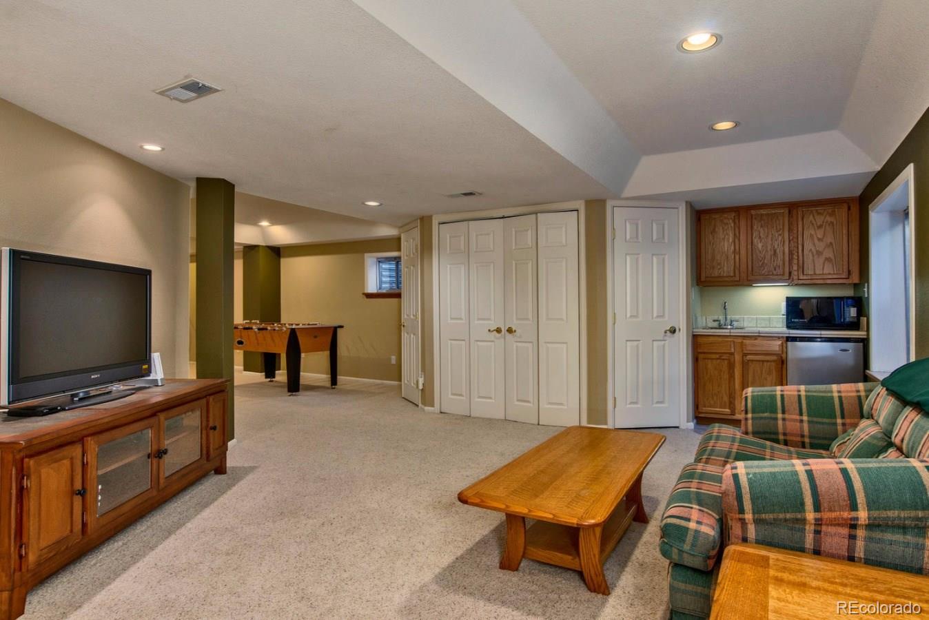 1757 Spring Water Place Highlands Ranch, CO 80129 - Photo 24 of 34 a living room with furniture and a flat screen tv