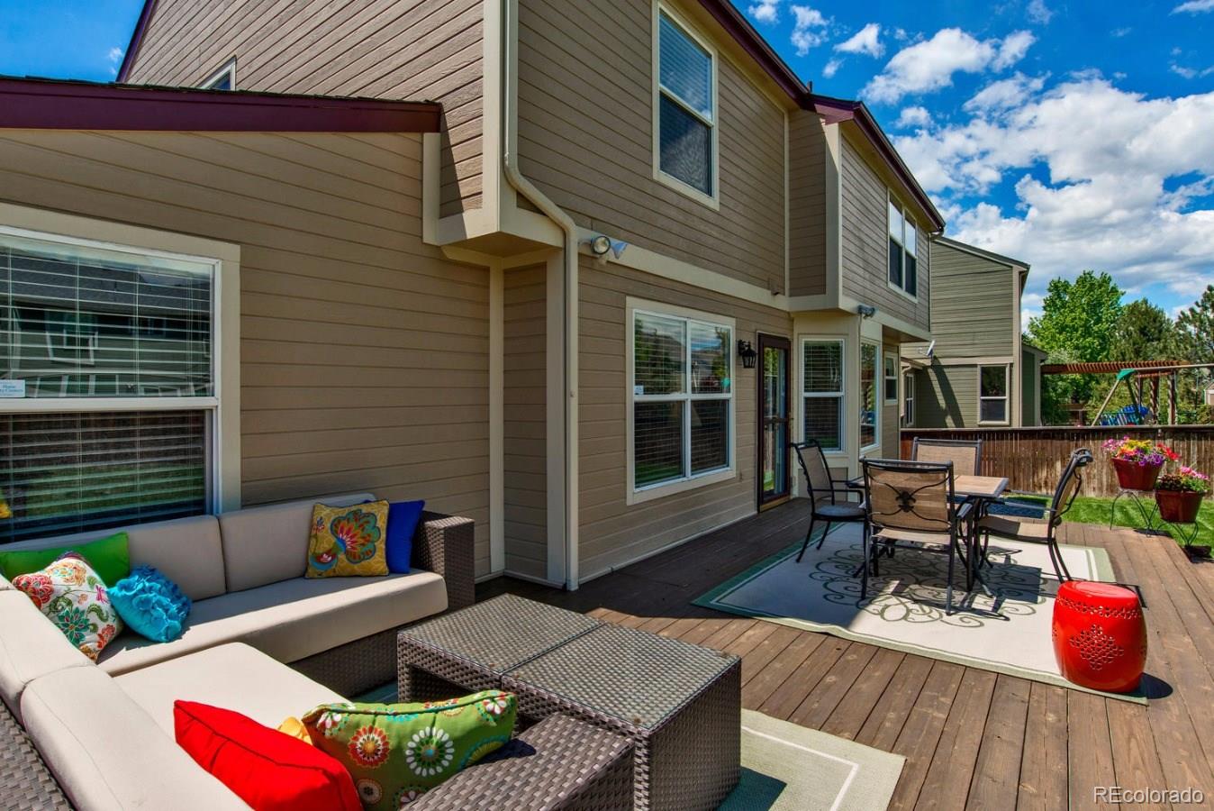 1757 Spring Water Place Highlands Ranch, CO 80129 - Photo 29 of 34 a view of a patio with couches and a table and chairs with wooden floor