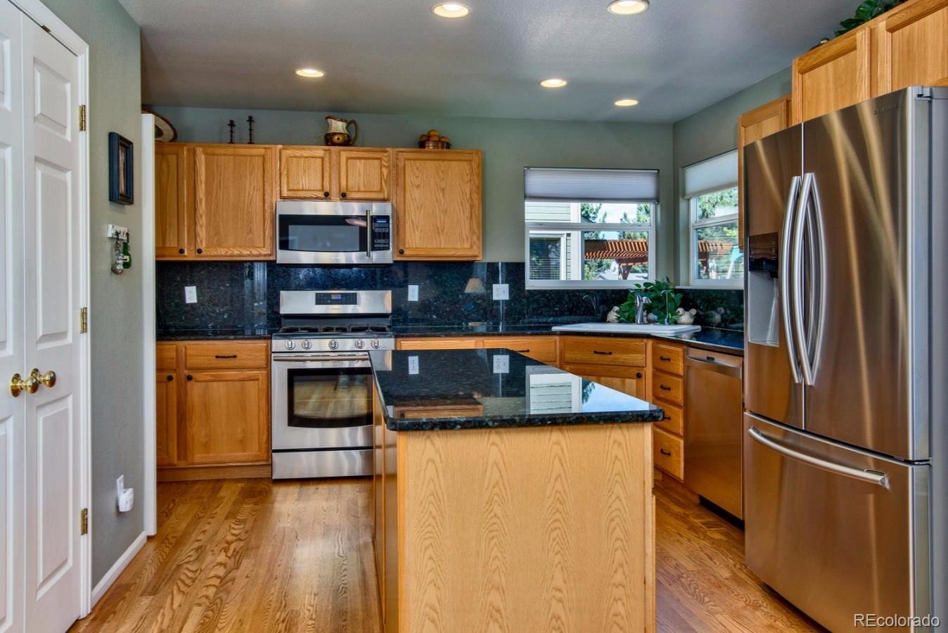 1757 Spring Water Place Highlands Ranch, CO 80129 - Photo 6 of 34 a kitchen with stainless steel appliances granite countertop a refrigerator a stove and a sink