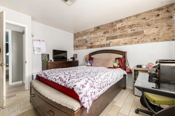 a bedroom with a bed and wooden floor