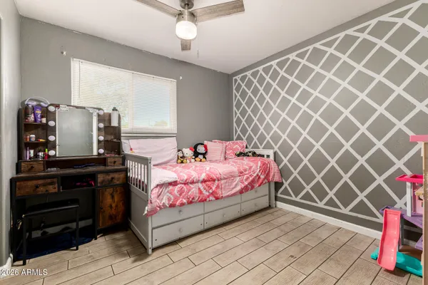 a bedroom with a bed and a flat tv screen on dresser
