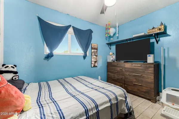 a bedroom with a bed and a flat tv screen