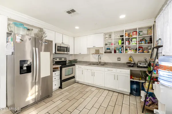 a kitchen with stainless steel appliances granite countertop a refrigerator and a stove top oven
