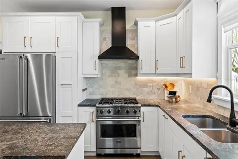 a kitchen with stainless steel appliances granite countertop a sink stove and refrigerator