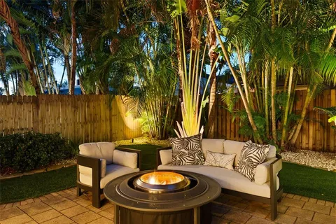 a backyard of a house with table and chairs plants and lake view