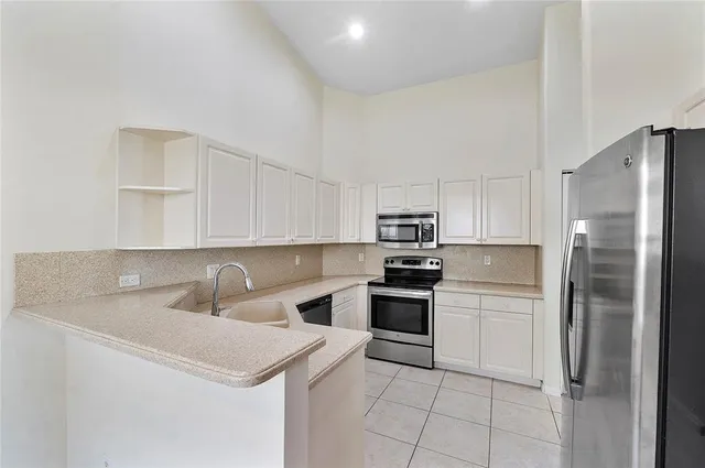 a kitchen with stainless steel appliances a refrigerator sink and cabinets