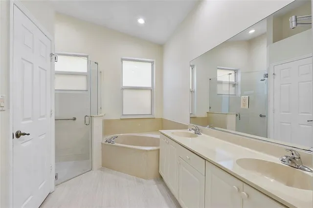 a bathroom with a tub sink and mirror