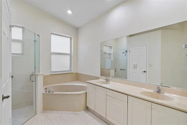 a bathroom with a tub a sink and mirror