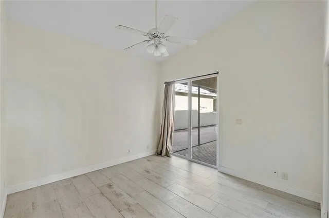 an empty room with fan and windows