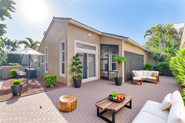 a view of a patio with couches table and chairs and potted plants