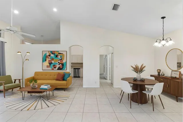 a living room with furniture a dining table and a chandelier