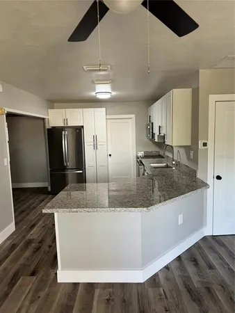 a view of a kitchen with stainless steel appliances granite countertop a refrigerator and a sink